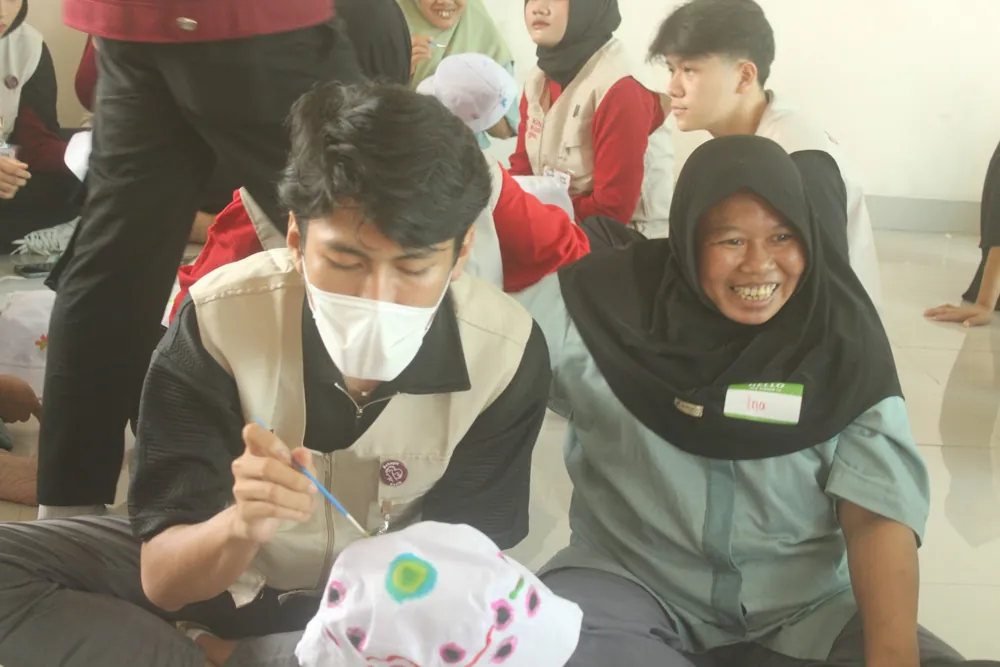 Relawan dan warga panti melukis topi bersama